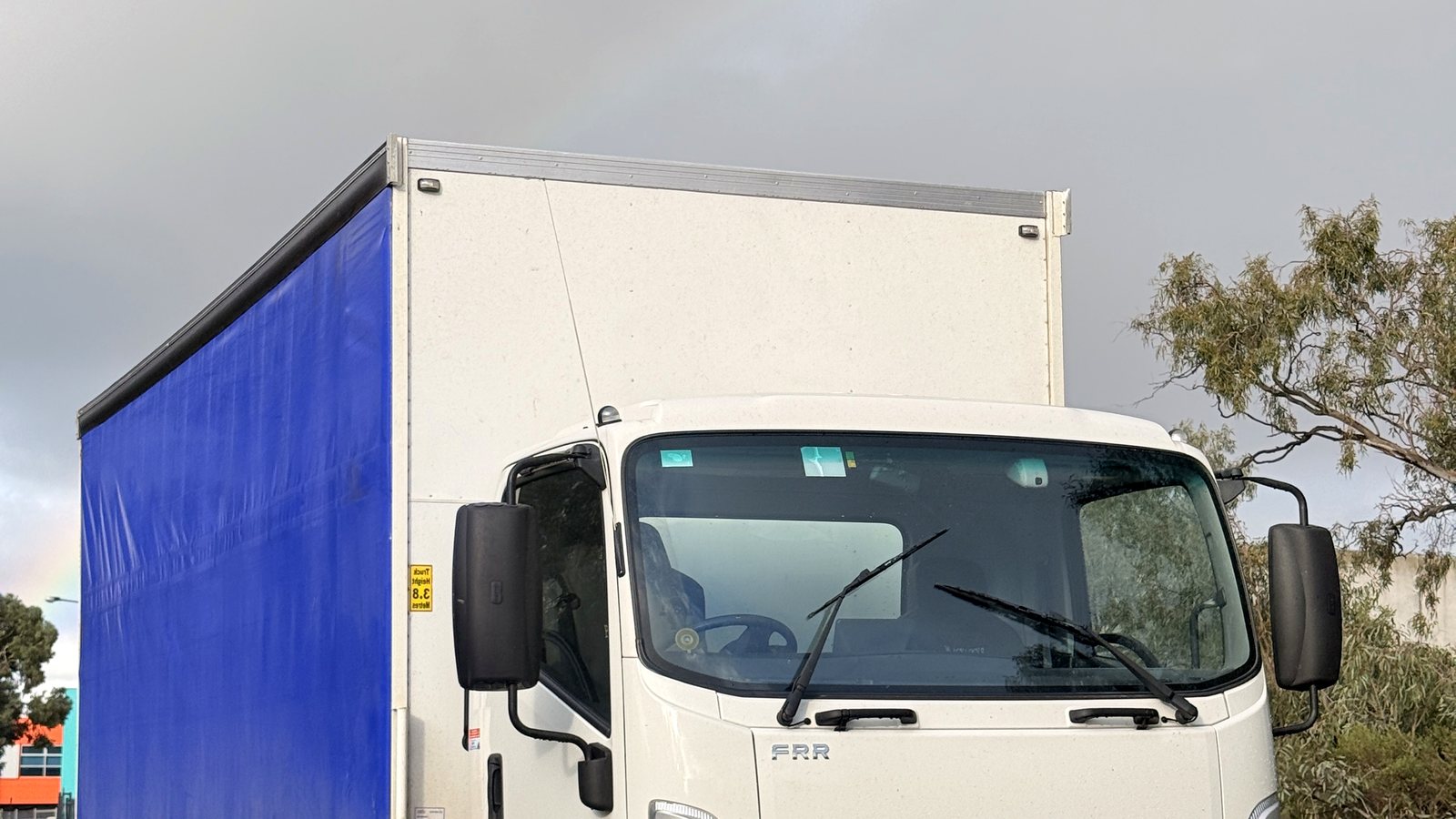 White Isuzu tautliner truck with blue curtain side